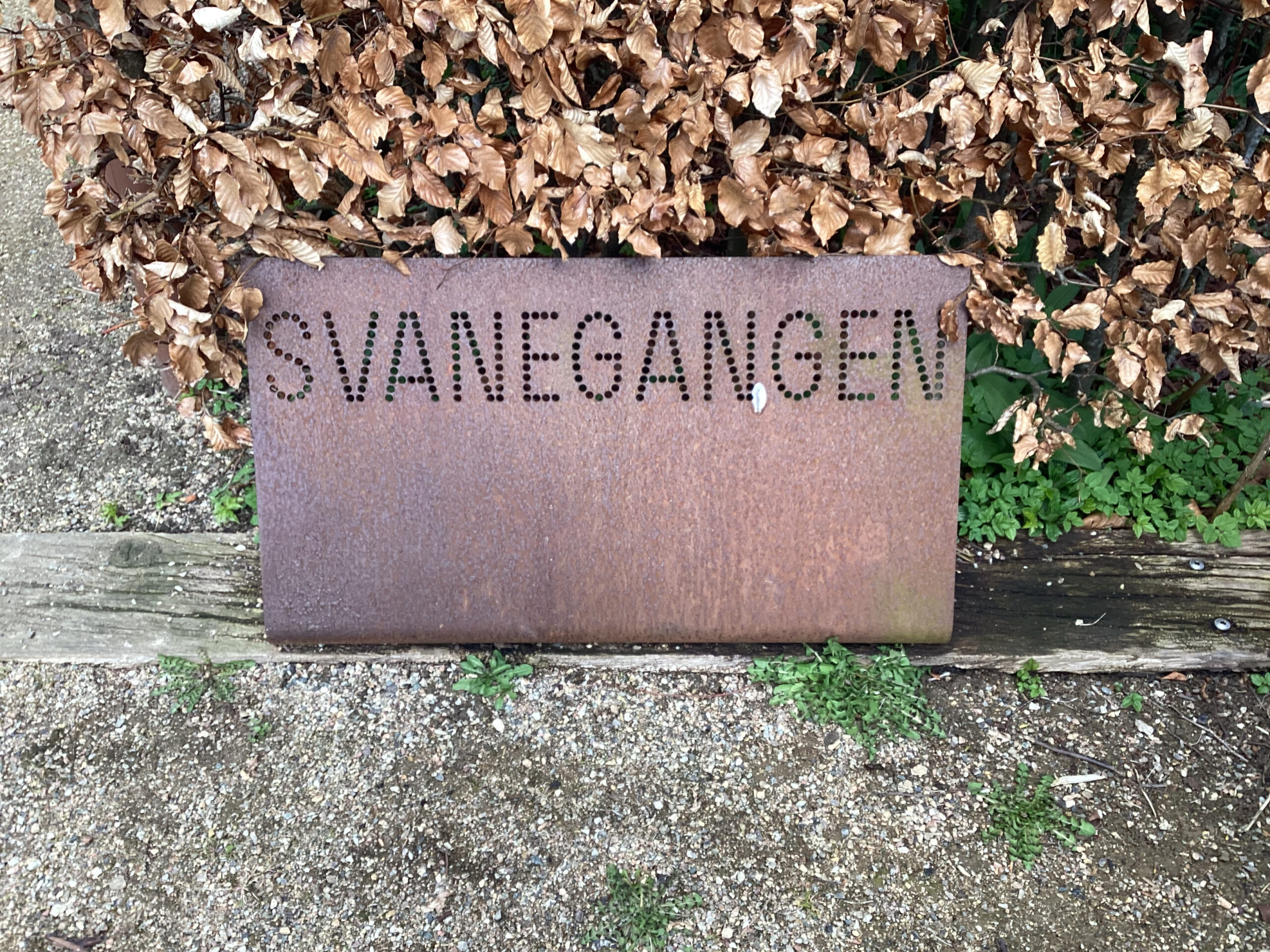 Indgraaveret "Svanegangen" i metalskilt