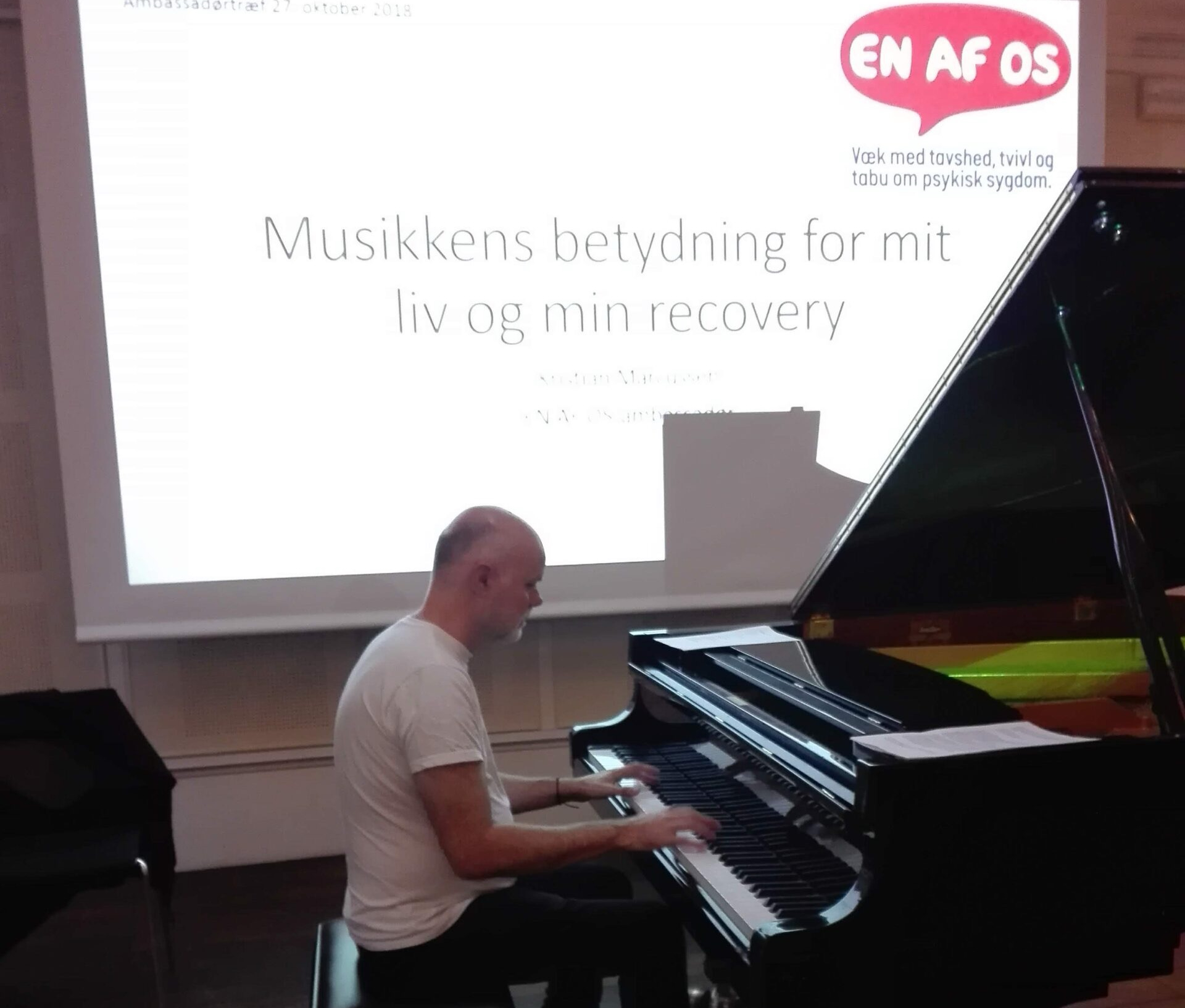 Kristian Marcussen spiller på flygel ved musikalsk foredrag for En af os