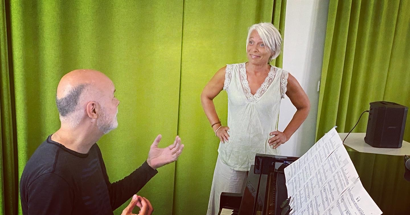 Pianist og sangerinde kommunikerer omkring flygel